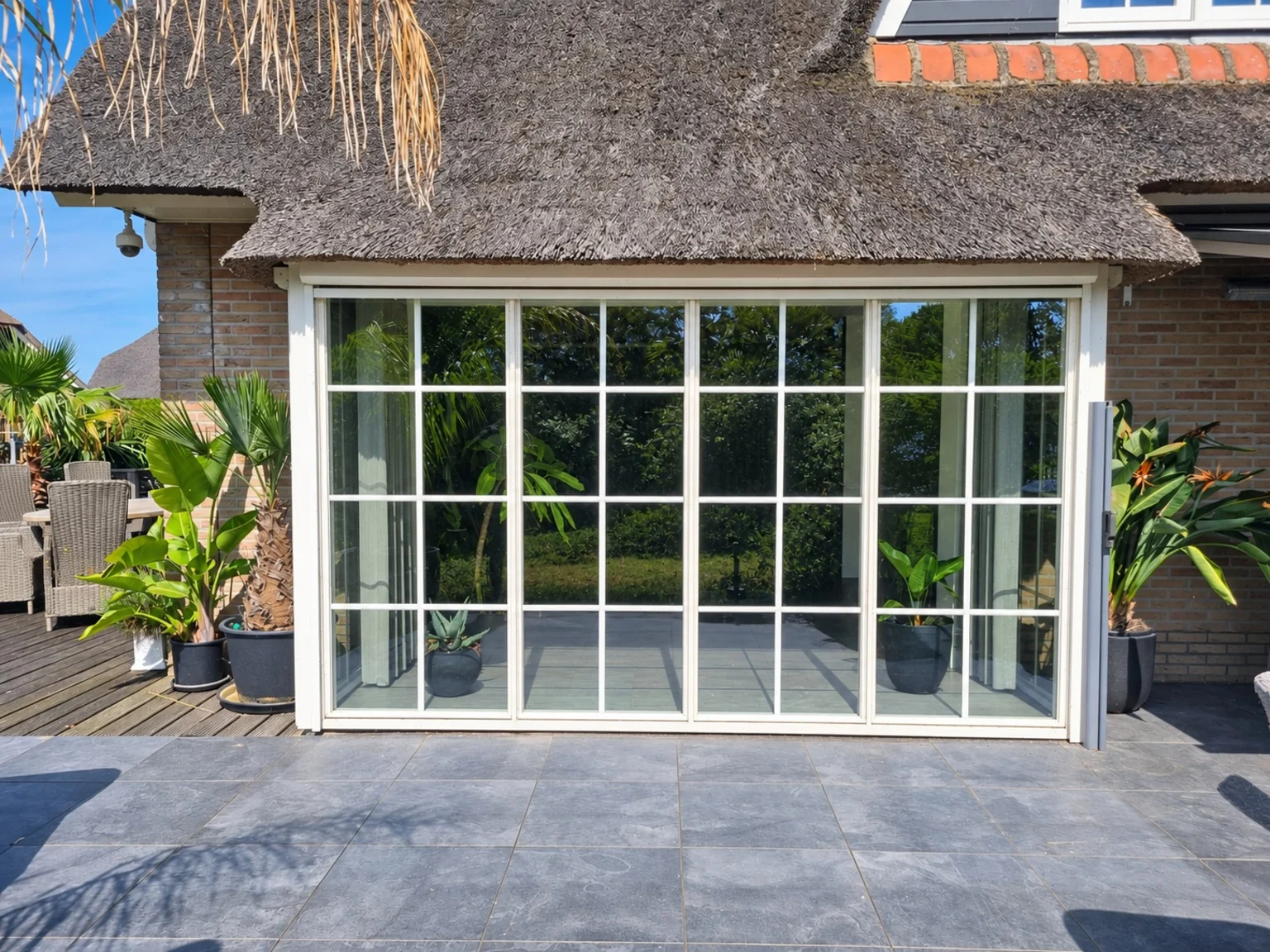 Glazen pui in een woning met rieten dak