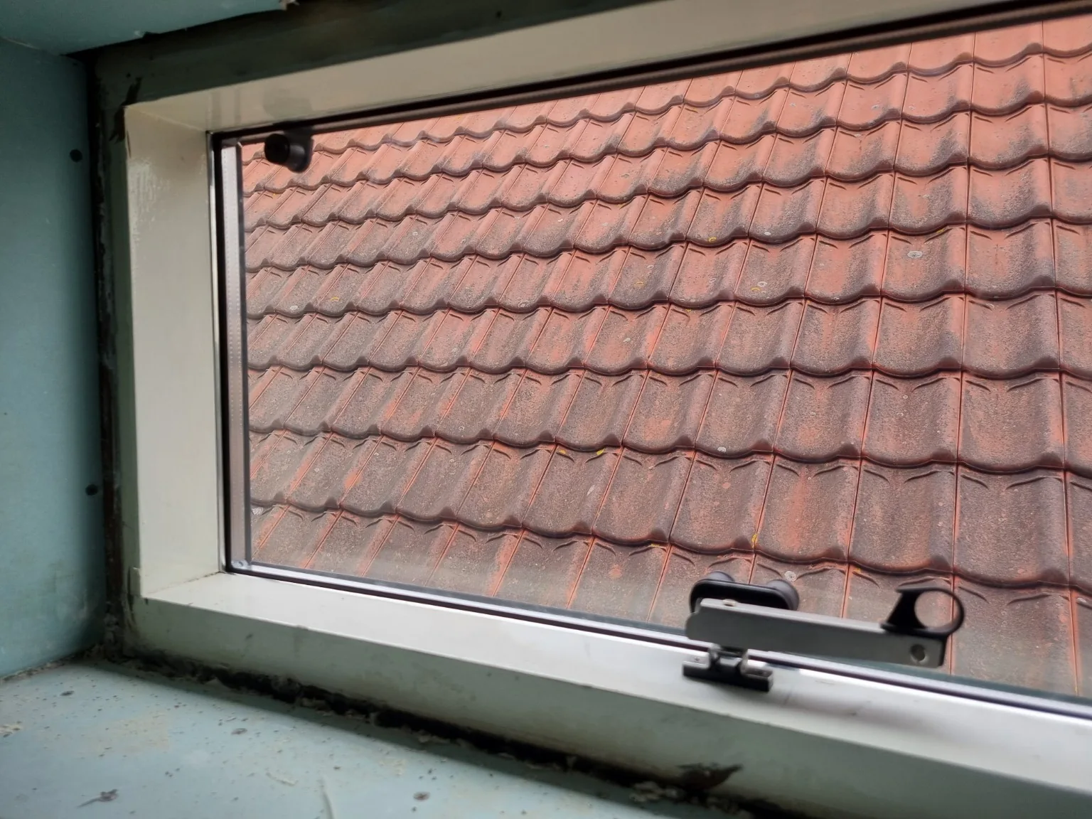 Binnenzijde van het hardglazen klapraam met de raamuitzetter in Stellendam